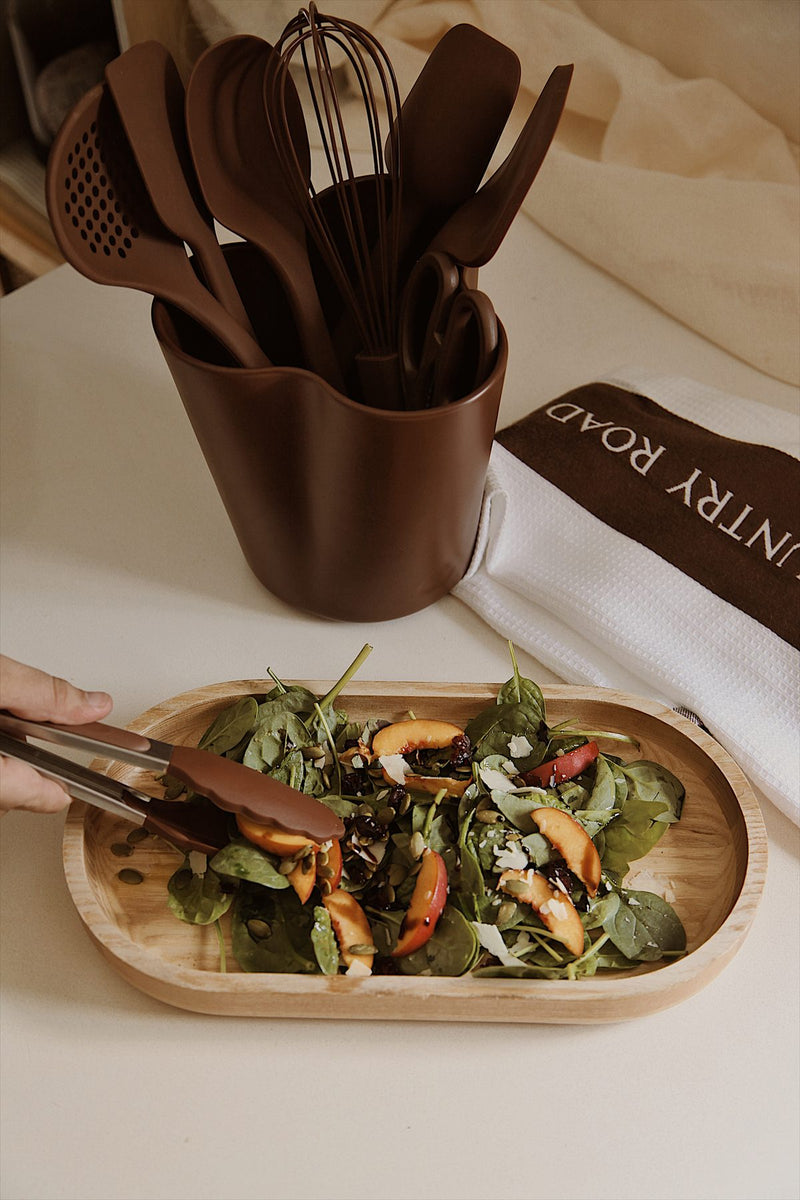 Mulberry tongs serving a peach and spinach salad